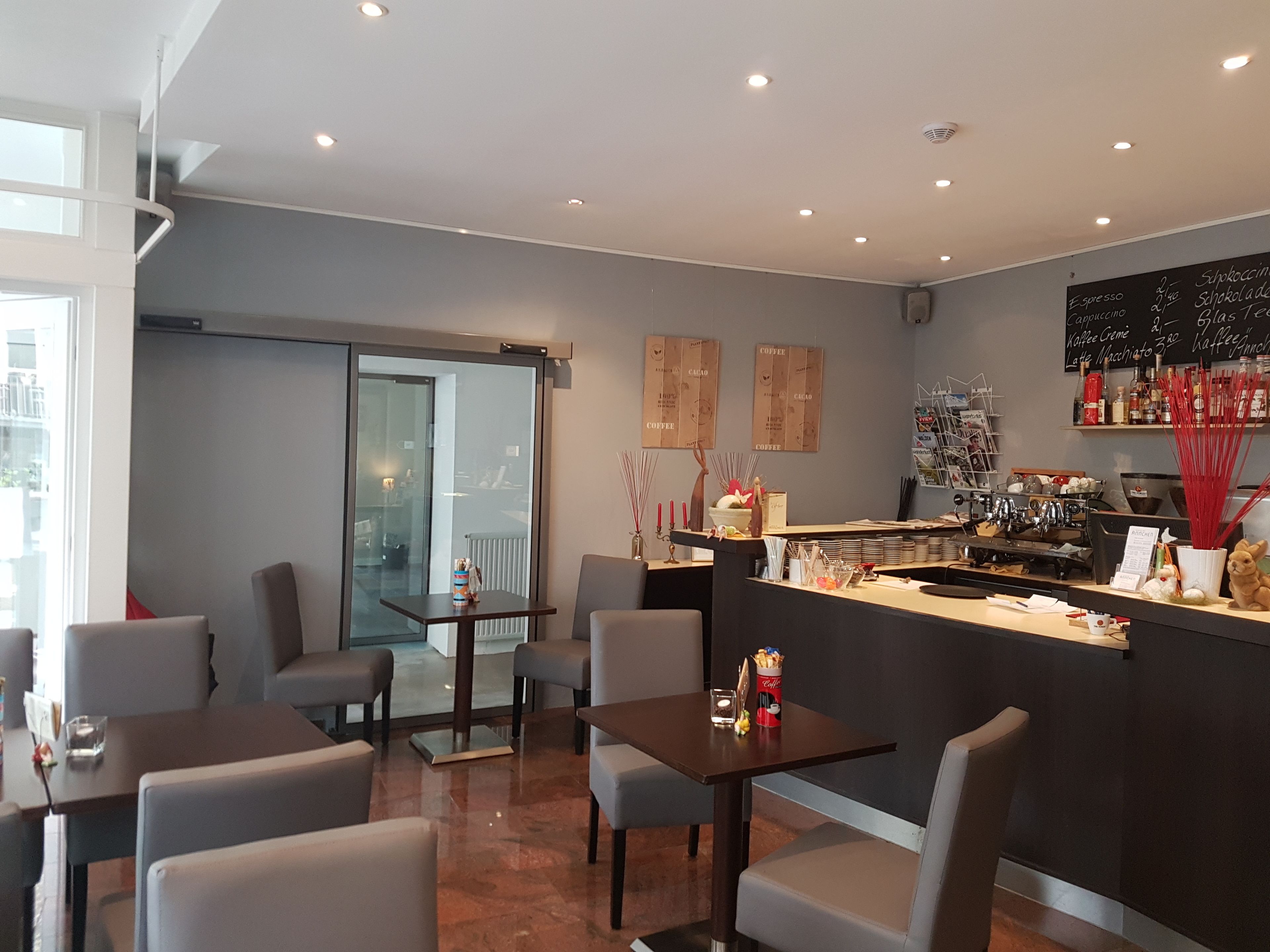 Un café moderno con barra, asientos y una pizarra de menú.