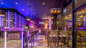 A modern bar area with a marble floor, multiple seating arrangements, and ambient lighting. - Admiral Hotel (Zagreb)