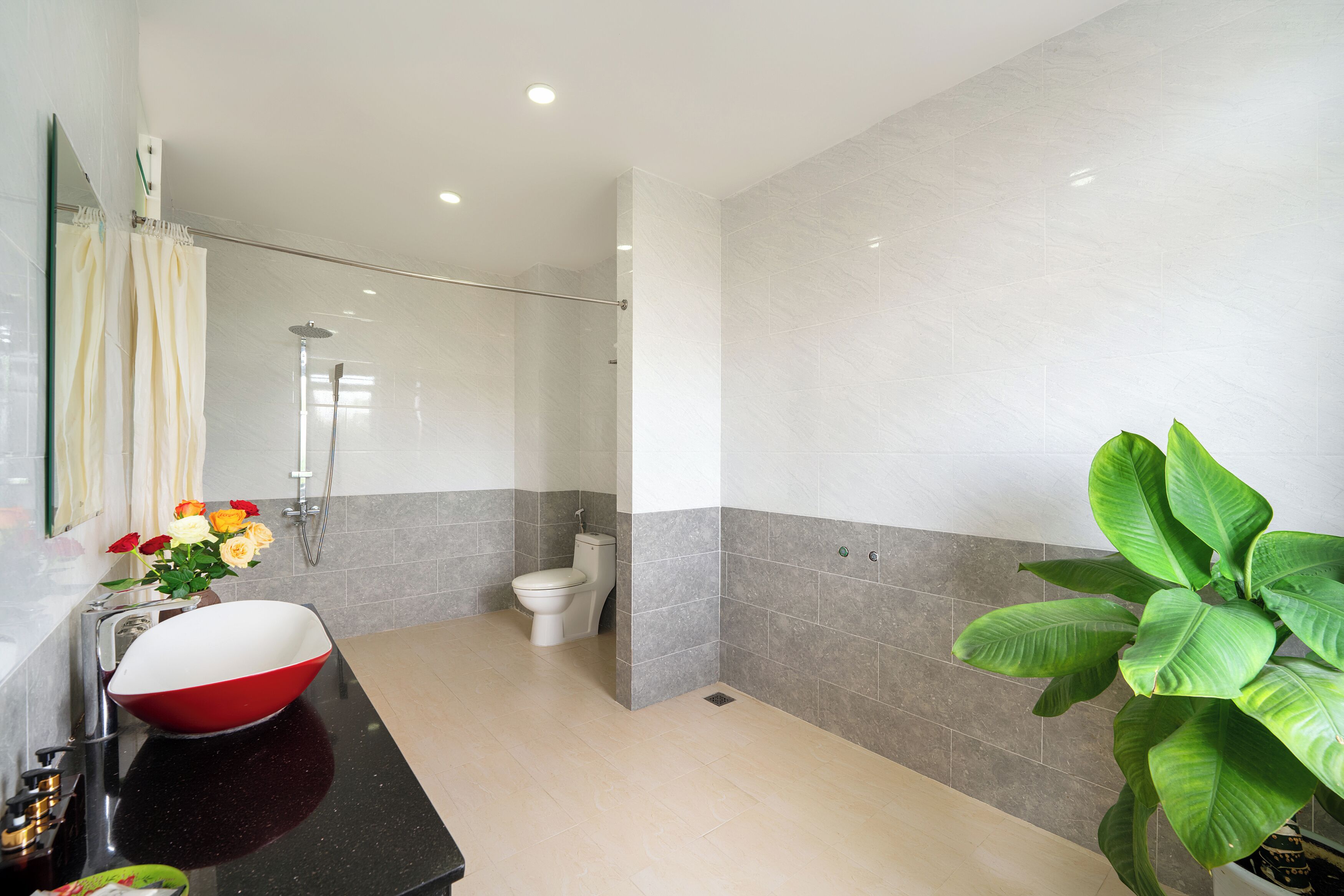 Uma casa de banho moderna com uma grande pia, sanita e chuveiro.