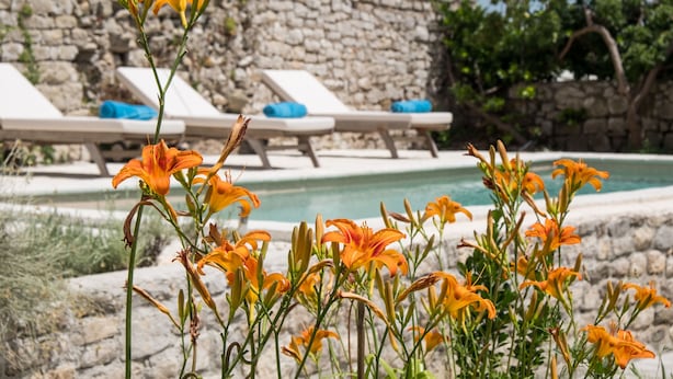 A pool area with stone walls and lounge chairs. - Unique Antistress Oasis Villa Antiqua  (Mali Losinj)