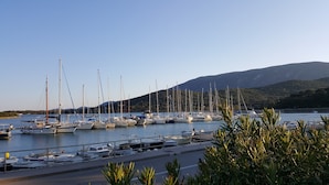 A marina with various boats docked, a clear sky, and a mountainous backdrop. - Unique Antistress Oasis Villa Antiqua  (Mali Losinj)