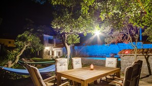 An outdoor dining area with a wooden table and chairs, a hammock, and a pool in the background. - Unique Antistress Oasis Villa Antiqua  (Mali Losinj)
