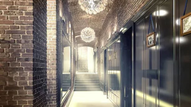 A corridor with brick walls, a chandelier, and a staircase leading to a higher floor. - Absyntapart Bulwar Staromiejski (Wroclaw)