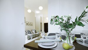 A dining table set with plates, glasses, and a vase with flowers. - Absyntapart Bulwar Staromiejski (Wroclaw)
