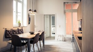 Een moderne keuken met houten kastjes en een eethoek met een houten tafel en stoelen.