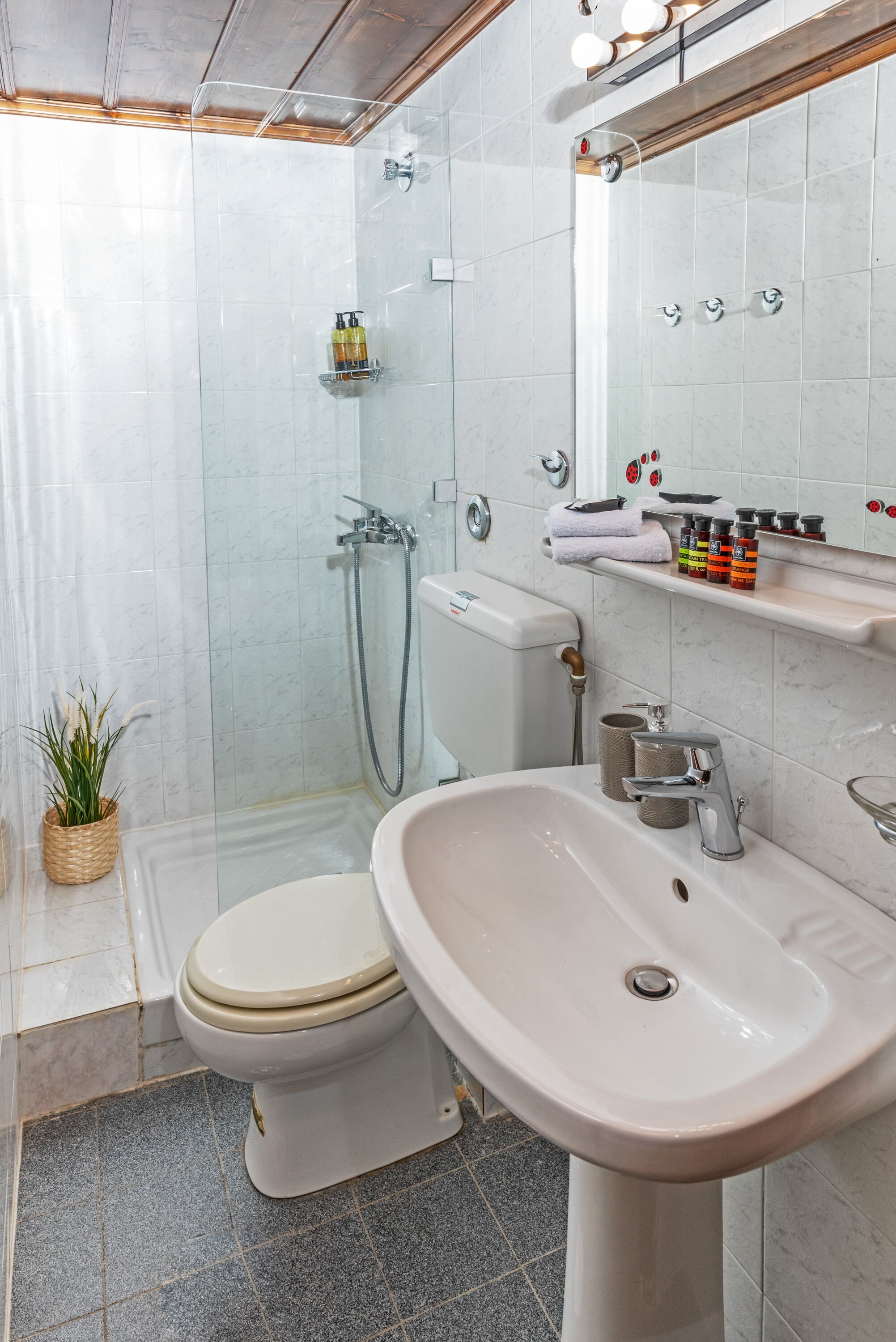 A modern bathroom with a toilet, sink, and shower.