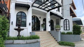 A hotel entrance with a fountain, steps, and a sign reading "The Seens Hotel." - The Seens Hotel (Krabi)