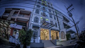 A multi-story building with a balcony on the second floor, a staircase leading to the entrance, and a sign indicating a hotel. - The Seens Hotel (Krabi)