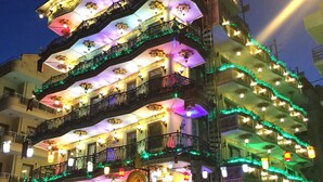 A multi-story building with balconies, ornate railings, and decorative lighting.