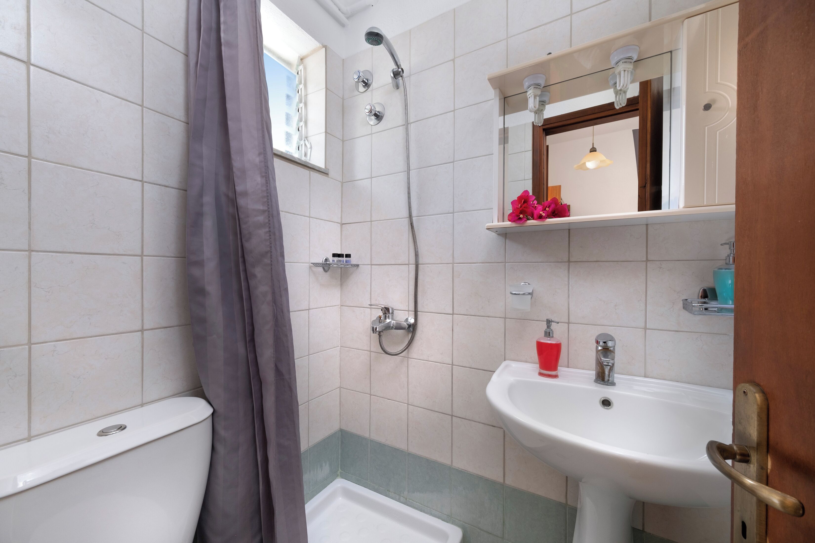 A bathroom with a shower, toilet, and sink.