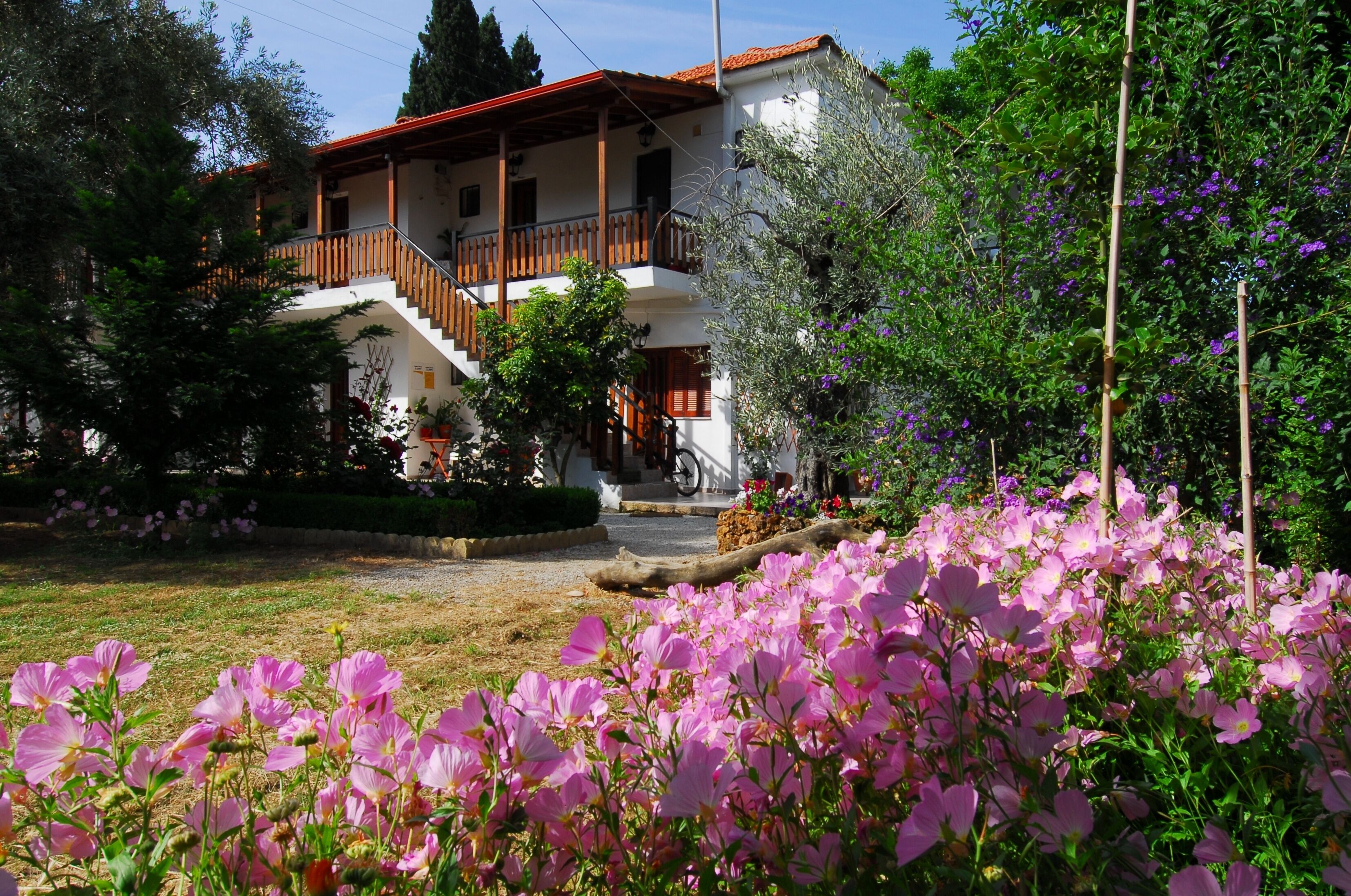 A two-story building with a wooden balcony and a staircase leading to the entrance.