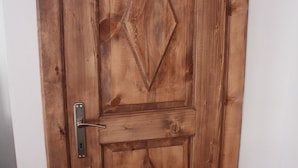 A wooden door with a metal handle and a diamond-shaped design. - Huseyin Bey Konagi (Safranbolu)