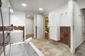 A modern bathroom with a bathtub, vanity, and shower area.