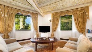 Una habitación amplia con una gran mesa redonda, dos sofás y un televisor de pantalla plana.