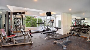 A modern gym with cardio machines, weightlifting equipment, and a bench. - ibis Styles Jakarta Simatupang (Jakarta)