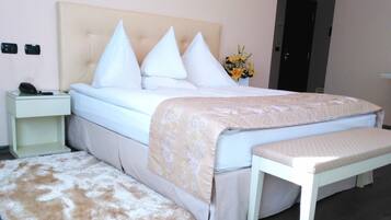 A neatly arranged bedroom with a bed, bedside tables, a bench, and a fluffy rug.