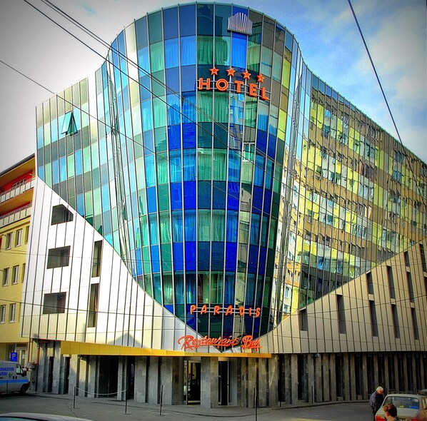 A modern hotel with a glass facade, a visible restaurant named "Restaurant Bar" at the ground level, and a sign indicating "HOTEL PARADIS." - Hotel Paradis Cluj Napoca (Cluj-Napoca)