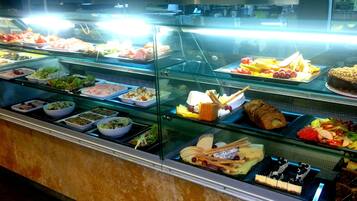 A buffet with various food items displayed in glass cases.
