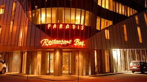 A hotel with a curved facade, illuminated signs reading "HOTEL" and "PARADIS Restaurant Bay." - Hotel Paradis Cluj Napoca (Cluj-Napoca)