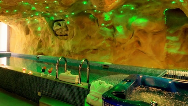 A spa with a large bathtub, a small pool, and a seating area with candles. - Hotel Paradis Cluj Napoca (Cluj-Napoca)