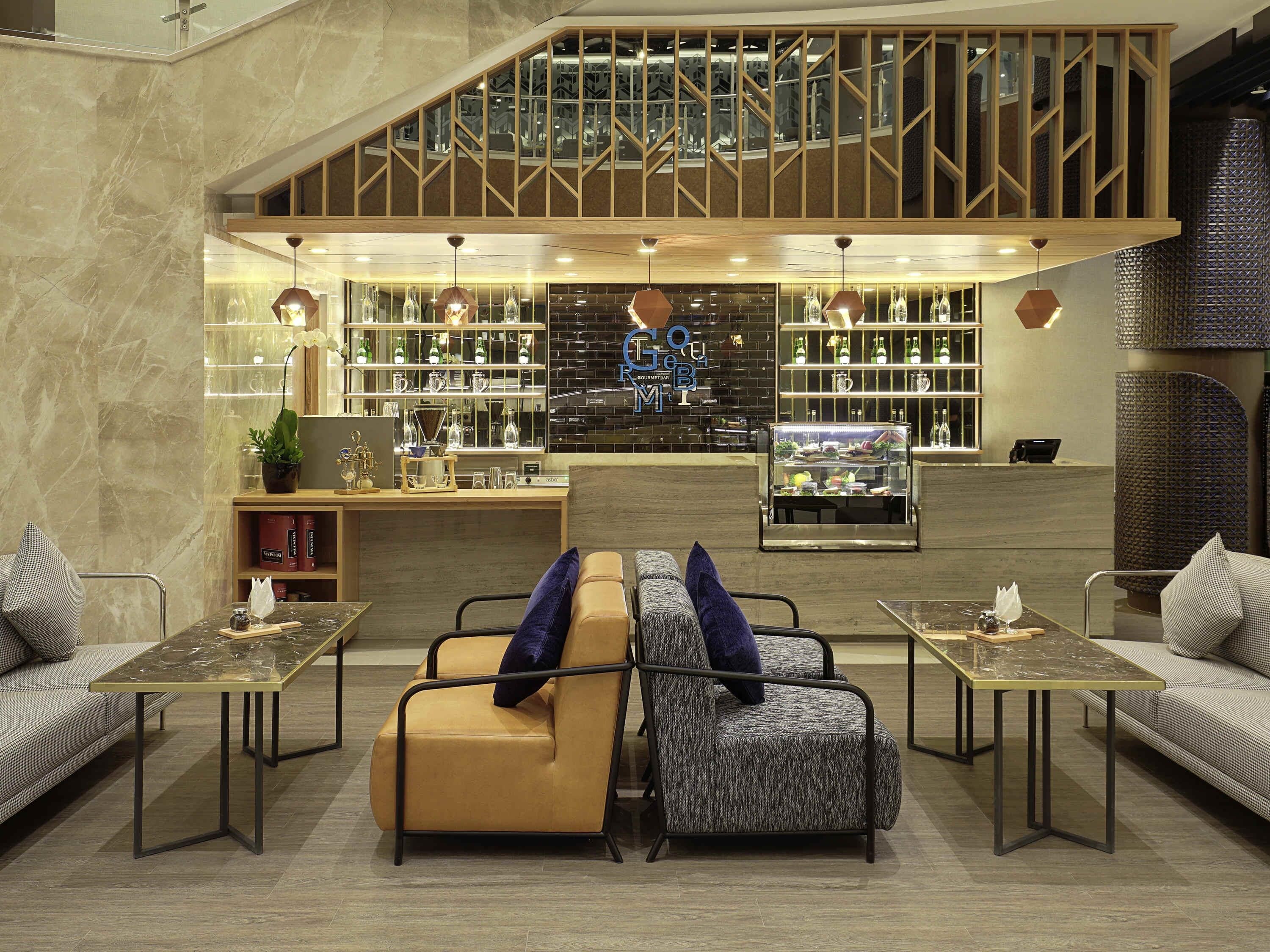 A modern interior with a bar area, seating, and a staircase.