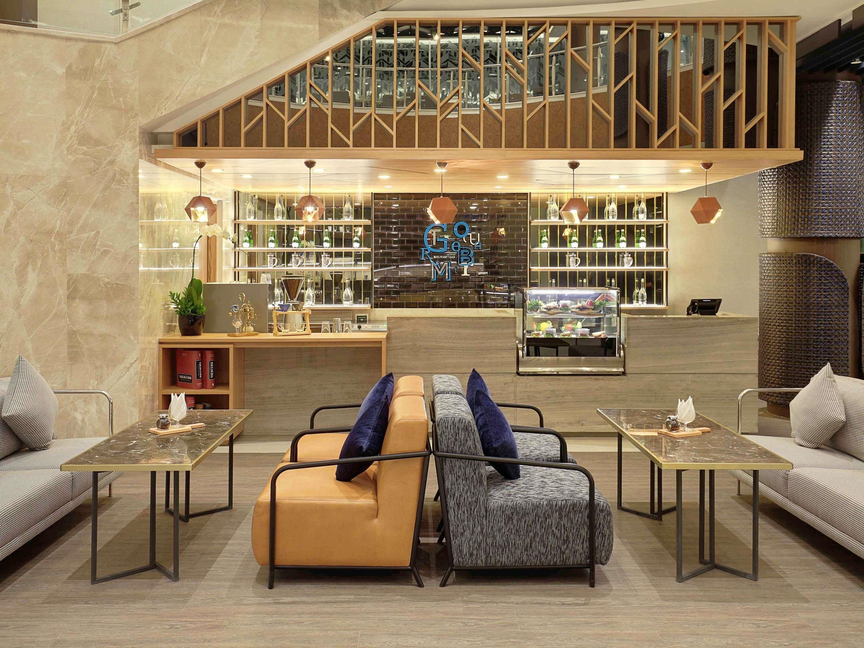 A modern interior with a seating area, a bar, and a staircase.