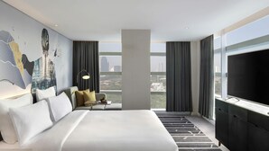 Une chambre d’hôtel moderne avec un grand lit, un bureau et une vue sur la ville.