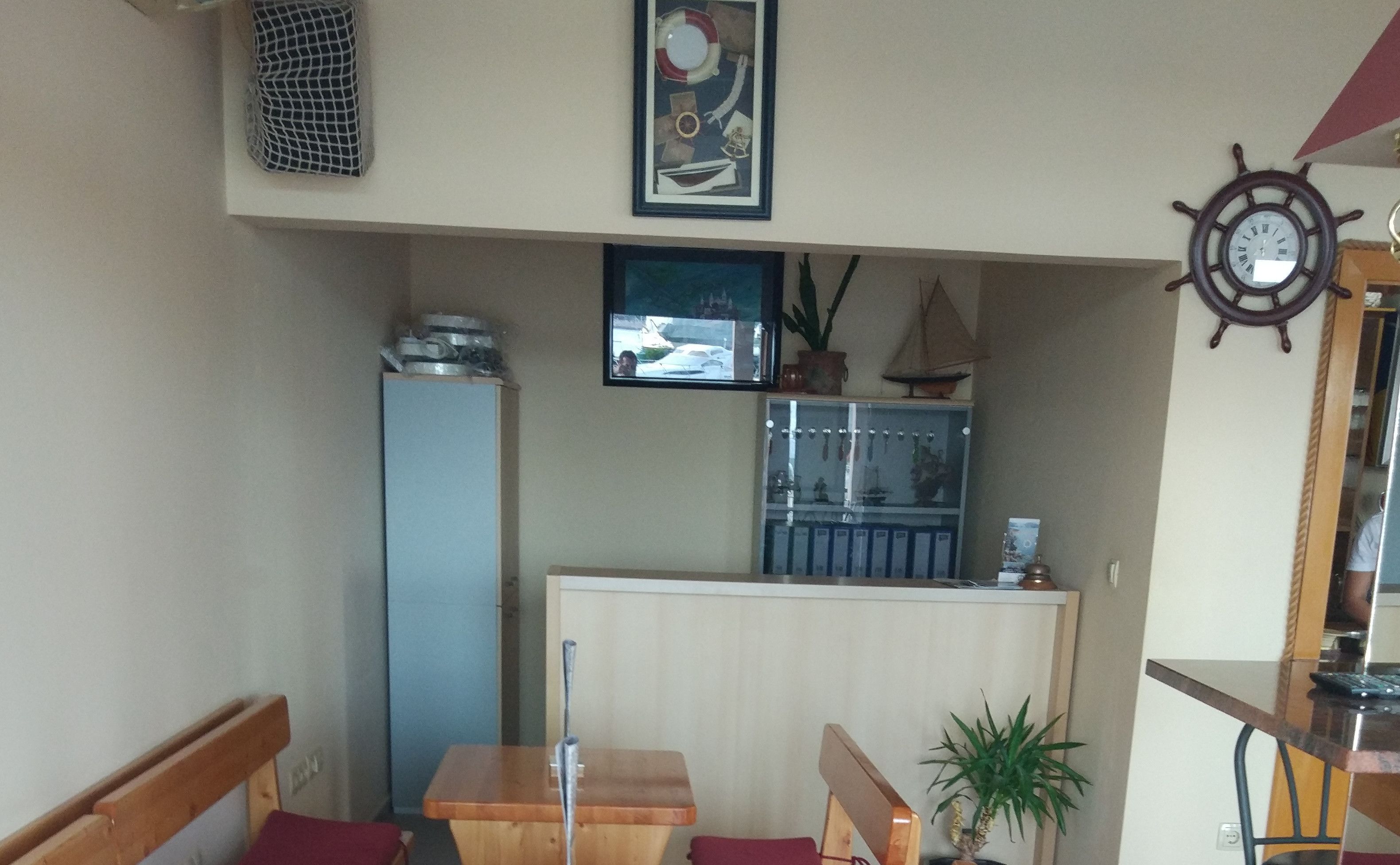 Um espaço de estar compacto com cozinha compacta, um pequeno espaço para refeições e uma janela com vista para a rua.