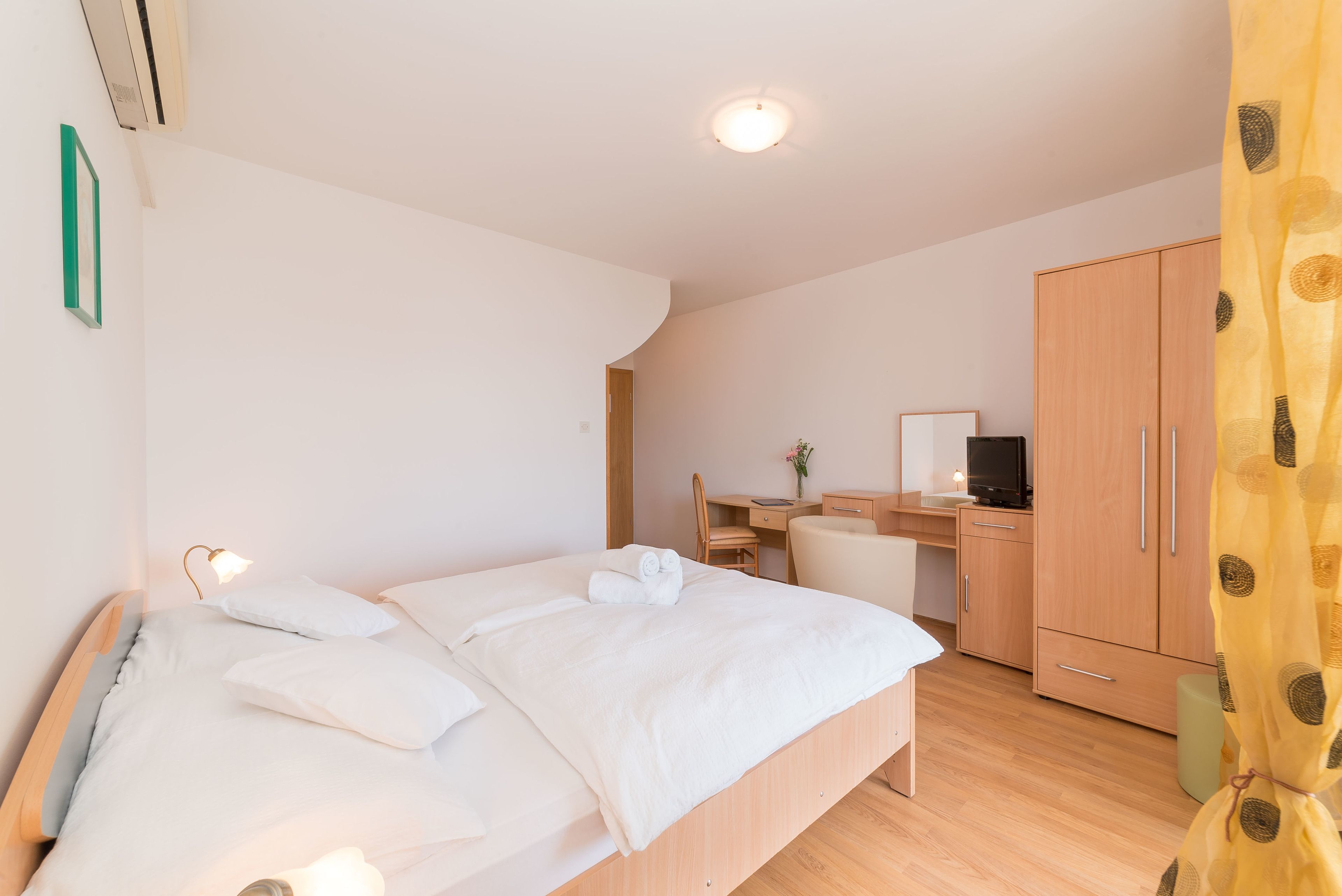 Un dormitorio con cama, escritorio, silla y armario.