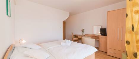 Un dormitorio con cama, escritorio, silla y armario.