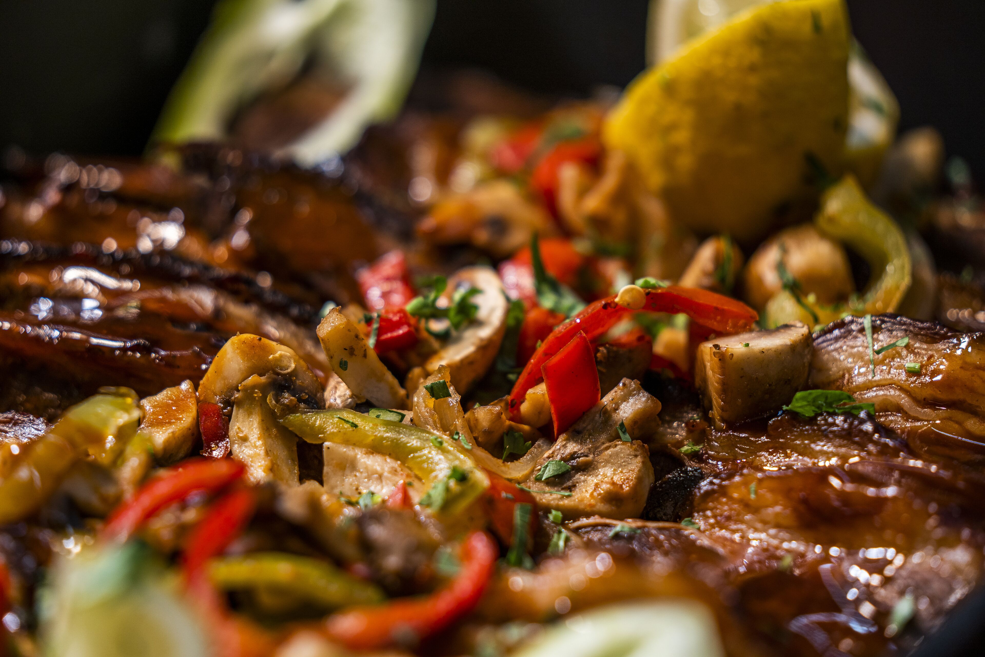 Primer plano de un plato con diversos vegetales y carne, adornado con hierbas.