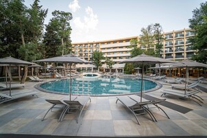 Una piscina al aire libre de temporada, sombrillas, tumbonas
