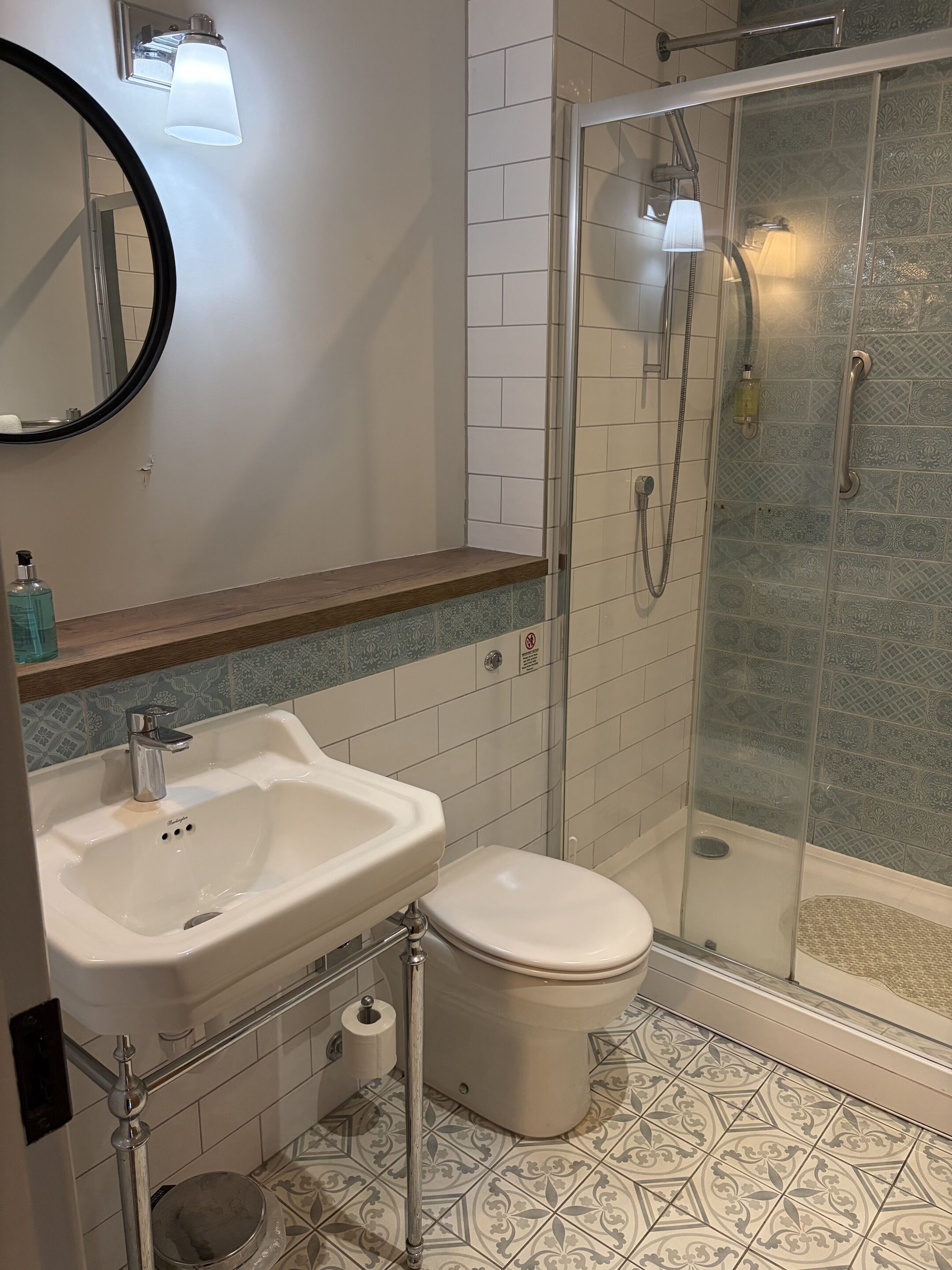 A bathroom with a white sink, toilet, and glass-enclosed shower.
