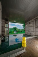 Una piscina interior moderna con vistas despejadas a un exuberante paisaje verde.