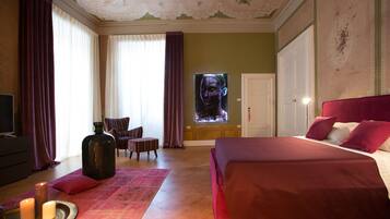 Ein Hotelzimmer mit einem großen Bett, einem Fernseher, einem Kamin und Blick auf die Stadt.