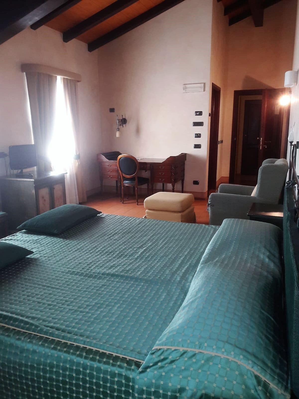 Una stanza con un letto grande, una scrivania, una sedia e un tavolino.