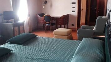 Una stanza con un letto grande, una scrivania, una sedia e un tavolino.