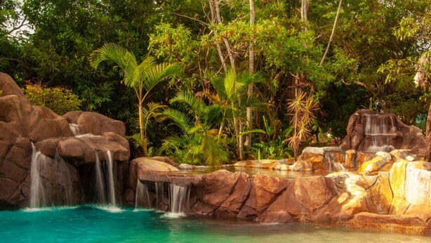 A natural pool with multiple waterfalls surrounded by lush greenery. - Pousada Caminho das Cachoeiras (Alto Paraíso de Goiás)