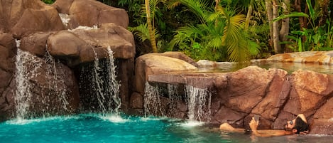 Una piscina al aire libre, sillones reclinables de piscina