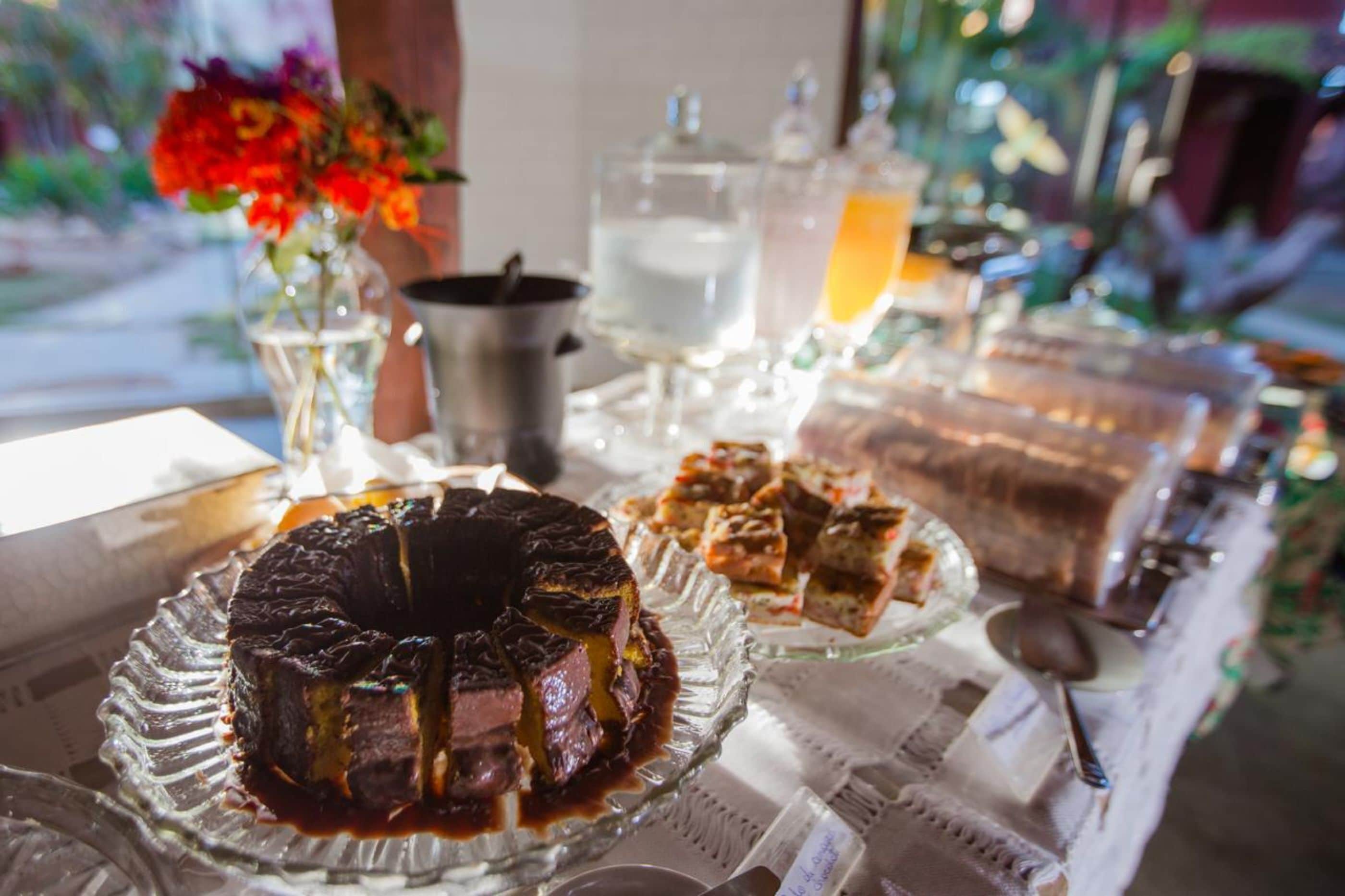 Une table avec un gâteau, une carafe et un verre de jus d’orange.