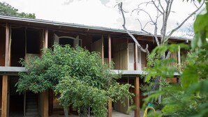 A traditional wooden building with a covered porch and a garden area. - Pousada Caminho das Cachoeiras (Alto Paraíso de Goiás)