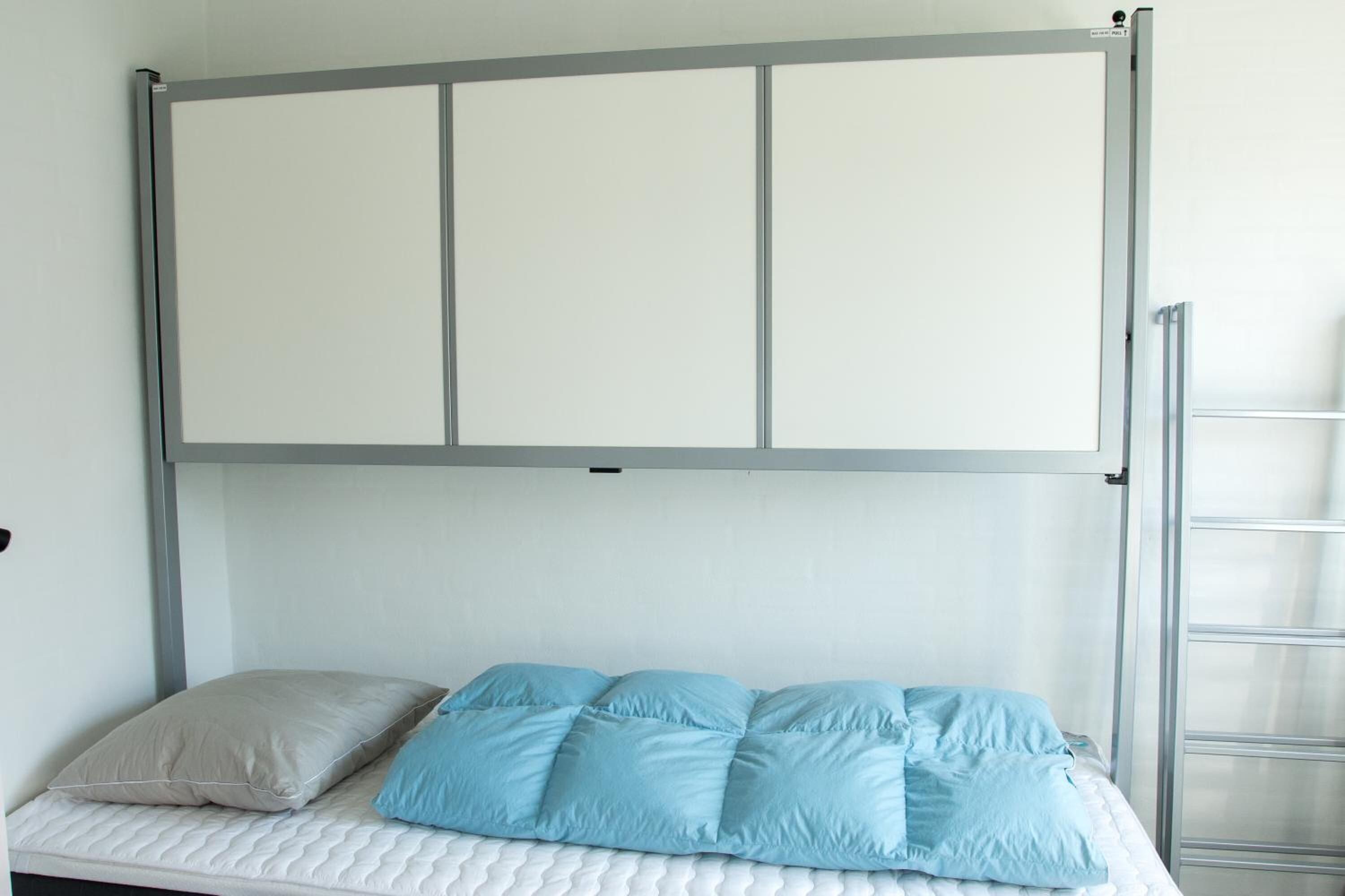 A bed with a metal frame, a mattress, and two pillows.