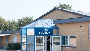 Un edificio con un toldo azul identificado con 