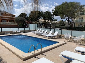 Une piscine équipée de chaises longues et d’un panneau indiquant une distance de 100 mètres.