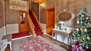 A grand lobby with a staircase, a reception desk, and a Christmas tree. - Mimoza Butik Otel Buyukada (Adalar)