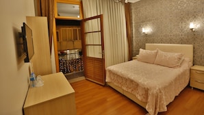 A hotel room with a bed, a desk, a wardrobe, and a bathroom visible through an open door. - Mimoza Butik Otel Buyukada (Adalar)