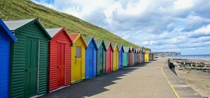 A row of colorful beach huts along a seaside promenade. - The Wheeldale (Whitby)