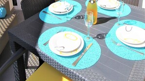 A dining area with a table set for four, a bottle of champagne, and a view of the kitchen and living area in the background. - Luxurious apartment with all comforts - 3 swimming pools - sunshine all day (adeje)