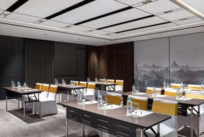 A conference room with tables, chairs, and a cityscape mural. - Wyndham Grand Yangon (Yangon)