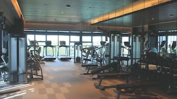 A gym with treadmills, weight machines, and benches.